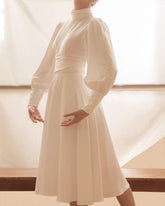 Robe midi en soie avec décolleté haut, détail trou de serrure et manches longues bouffantes pour une élégance raffinée