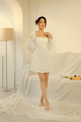 Silk mini dress with ruched bodice and puff sleeves featuring delicate bow-tie accents