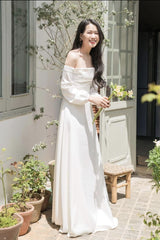 Robe longue en soie à épaules dénudées, manches longues et silhouette drapée flatteuse