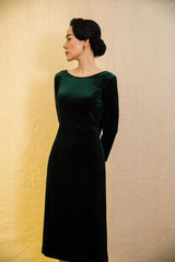 Velvet midi dress with long sleeves, boat neckline, and low back bow detail