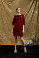 Velvet shift dress with oversized bow detail and relaxed sleeves for festive party looks